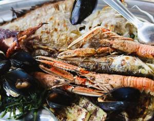 a plate of food with lobster and other seafood at PERFECT NEST at Sunset Beach in Vela Luka