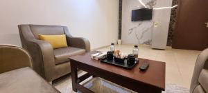 een woonkamer met 2 stoelen en een salontafel bij رونزا الشميسي in Riyad