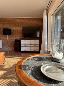 een woonkamer met een tafel met een tv en een tafel sidx sidx bij Ars Vivendi in Strasen