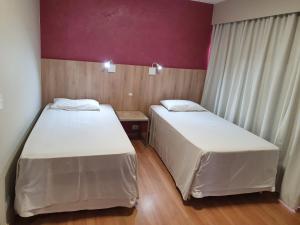 two beds in a small room with at Alta Reggia Plaza Hotel in Curitiba