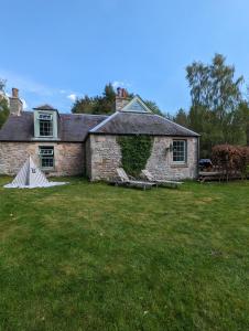 an old stone house with an ivy growing on it at Birkenside Cottage in Jedburgh