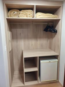 a closet with wooden shelves at Alta Reggia Plaza Hotel in Curitiba
