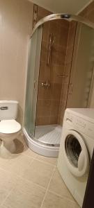 uma casa de banho com um chuveiro e uma máquina de lavar roupa em Europroperties Bendita Mare Apartments em Golden Sands