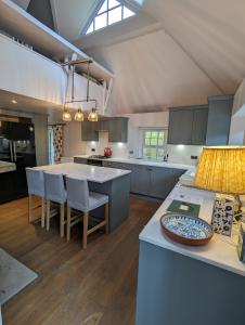 a kitchen with a large island with chairs and a table at Birkenside Cottage in Jedburgh
