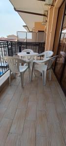 balkon z białymi stołami i krzesłami w budynku w obiekcie Europroperties Bendita Mare Apartments w Złotych Piaskach