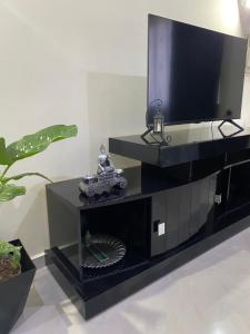 a black entertainment center with a flat screen tv at T1 Férias Mindelo in Mindelo