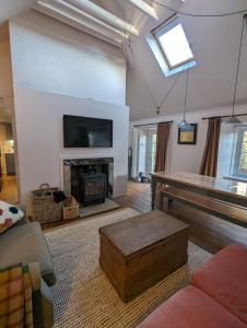 a living room with a fireplace and a tv at Birkenside Cottage in Jedburgh