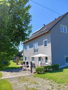 a house with a patio and an umbrella at Ferienwohnung Pinzenhof - Kemnath in Kemnath