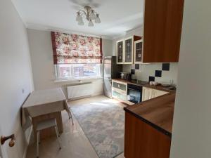 Апартаменты ЖК Сезим кала Бакыт Туран 55/12 في Taldykolʼ: مطبخ صغير مع طاولة ونافذة