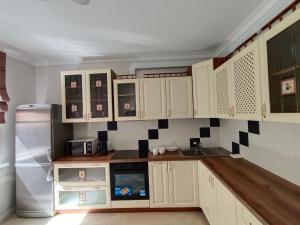 Апартаменты ЖК Сезим кала Бакыт Туран 55/12 في Taldykolʼ: مطبخ مع خزائن بيضاء وثلاجة