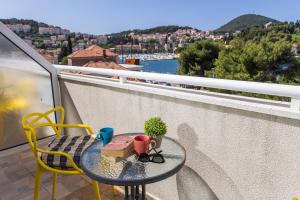 a table and chairs on a balcony with a view at Hostel Petra Marina in Dubrovnik