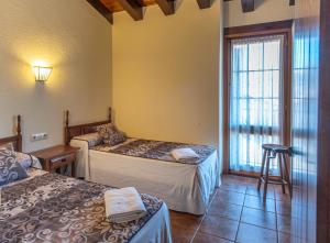 Zimmer mit 2 Betten und einem Fenster in der Unterkunft Can Tubau - Casa rural - Apartaments in Campelles