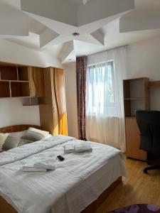 - une chambre avec un grand lit blanc et une fenêtre dans l'établissement Special apartment NADEVA, à Suceava