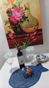 アリカンテにあるAlicante Postiguet Apartmentsの絵画とワインのボトルとグラスを用意したテーブル