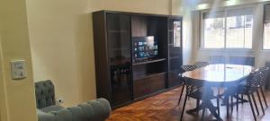 Un comedor con una mesa y un televisor. en Departamento 4 ambientes, 3 hab, en Buenos Aires