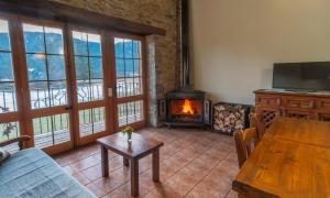 un soggiorno con tavolo in legno e camino di Can Tubau - Casa rural - Apartaments a Campelles