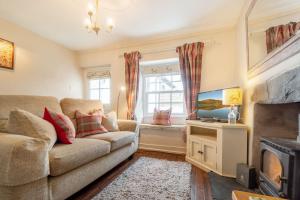 a living room with a couch and a tv at Gingerbread Cottage in Hawkshead +4 photos