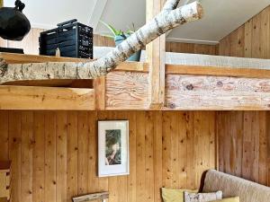 une branche d'arbres sur le mur d'une pièce avec des murs en bois dans l'établissement Holiday home INGARÖ V, à Grönskan