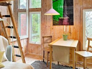 Cette chambre comprend une table, des chaises et des fenêtres. dans l'établissement Holiday home INGARÖ V, à Grönskan