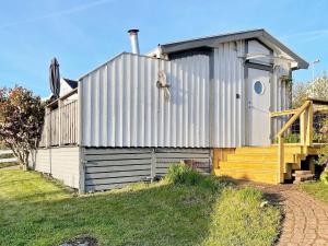 a large metal building with a porch and stairs at 2 person holiday home in V JERN in Väjern