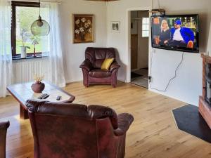 a living room with a couch and a tv at Holiday home HÖGSBY II in Högsby