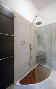 a bathroom with a glass shower with a sink at Lollo Apartment in Mantova