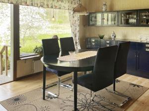 uma cozinha com uma mesa e cadeiras numa cozinha em Holiday home Svanesund VI em Svanesund