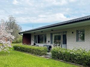 a white brick house with a lawn in front of it at Holiday home Svanesund VI in Svanesund