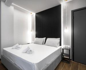 1 dormitorio con cama blanca y pared negra en Xanthi's House en Xanthi