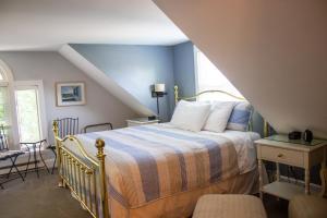 a bedroom with a bed with a blue wall at Bourne Bed and Breakfast in Ogunquit