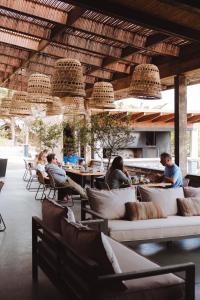 un grupo de personas sentadas en mesas en un restaurante en Hotel Alaia, en Pichilemu