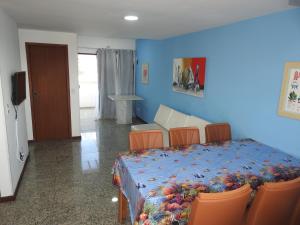 a bedroom with a bed with chairs and a blue wall at Cobertura Canto da Sereia in Arraial do Cabo