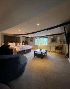 Red Lion Hotel, Pub & Restaurant في Betchworth: غرفة نوم كبيرة مع سرير وأريكة