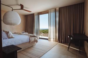 1 dormitorio con cama y ventana grande en Hotel Alaia en Pichilemu