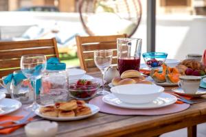 una mesa con platos de comida y copas de vino en Casa mare & spa Alghero, en Alghero