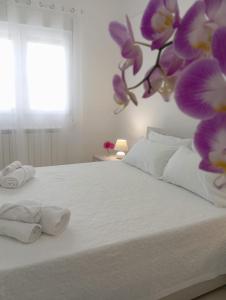 a bedroom with a white bed with towels on it at Loredana Affittacamere in Vittoria