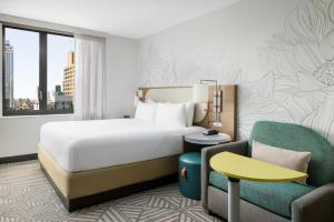 a hotel room with a bed and a chair at SpringHill Suites by Marriott New York Manhattan Chelsea in New York