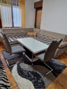einen Tisch und Stühle im Wohnzimmer mit Sofa in der Unterkunft Sobe Lejla in Vipava
