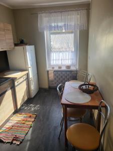 une petite cuisine avec une table et un réfrigérateur dans l'établissement APARTAMENT PRZY WYSPIE, à Darłowo