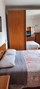 1 dormitorio con 2 camas y espejo en Appartamento mare Torvaianica via Pola, en Torvaianica