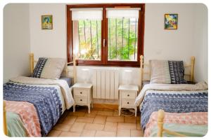 um quarto com 2 camas e uma janela em Appartement confortable entre Paris et Disney em Villiers-sur-Marne