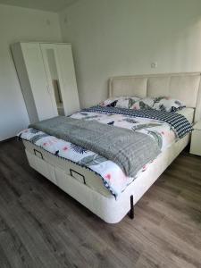 a bed in a bedroom with a white bed frame at Sobe Lejla in Vipava