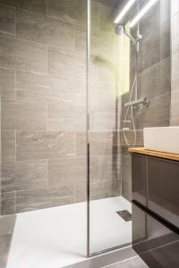 a shower with a glass door in a bathroom at Aurora Suite à Champel avec terrasse in Geneva