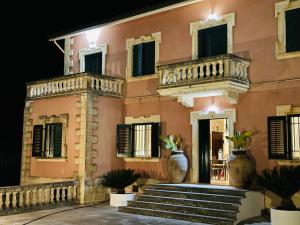 a building with two balconies and stairs in front at Gio Country House in Nicosia
