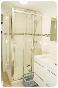 y baño con ducha y puerta de cristal. en Appartement confortable entre Paris et Disney, en Villiers-sur-Marne