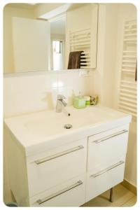 a white bathroom with a sink and a mirror at Appartement confortable entre Paris et Disney in Villiers-sur-Marne
