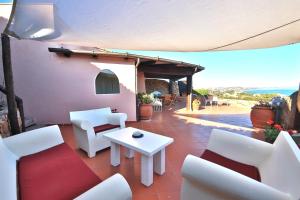 a patio with white chairs and a white table at Cottage Sardinia by KlabHouse in Palau +21 photos