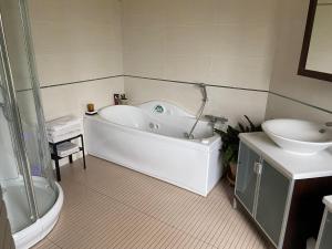 a bathroom with a tub and a toilet and a sink at Villa Serenity in Chambourcy
