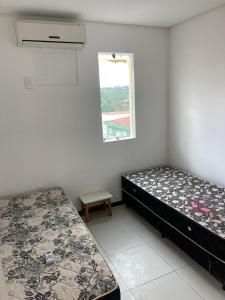 1 dormitorio con 2 camas y ventana en Casa para temporada - São João 2024 en Campina Grande