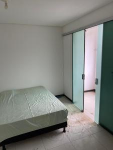 1 dormitorio con 1 cama y puerta corredera de cristal en Casa para temporada - São João 2024 en Campina Grande